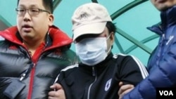 Penjaga Pantai Korea Selatan menggiring kapten kapal nelayan Tiongkok (tengah) pasca perawatan medis di rumah sakit Incheon (12/12).