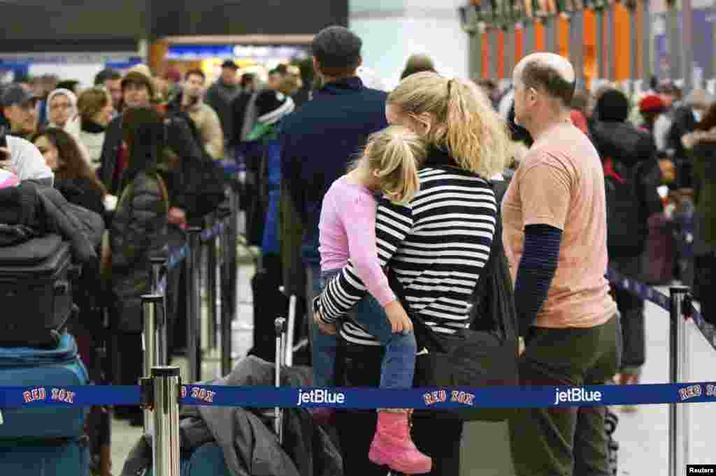 A woman and a young girl wait in line at Logan International Airport during a snow storm in Boston, Jan. 2, 2014. 