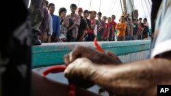 Government official puts wrist bands on recently rescued Burmese fishermen for identification purposes upon their arrival in Tual, Indonesia, April 4, 2015.