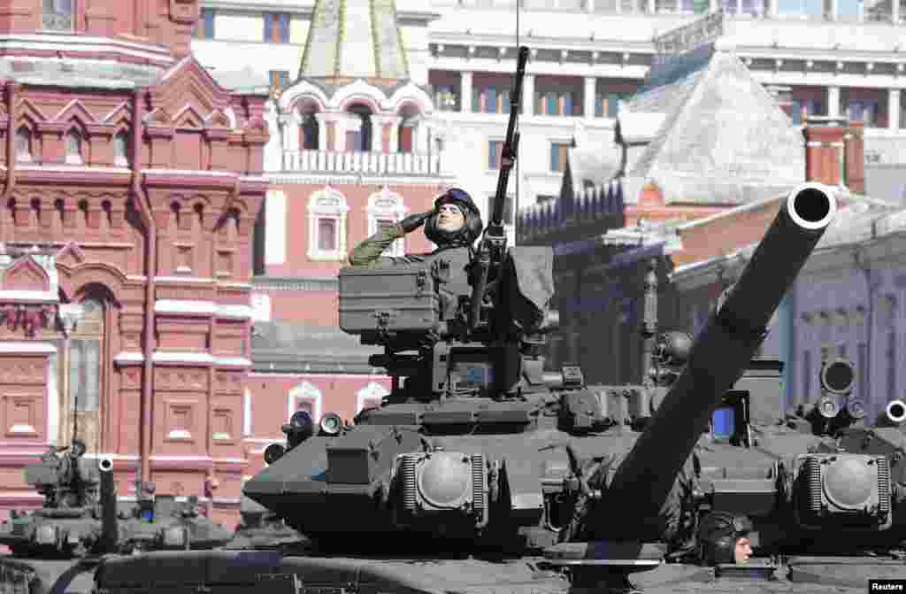 A Russian serviceman aboard a tank salutes during the Victory Day parade in Moscow&#39;s Red Square.