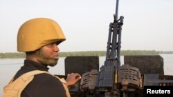 (File) A naval officer mans a machine gun boat off Nigeria's coast. Forty vessels have been attacked by armed gangs in the Gulf of Guinea this year, according to senior US military officials.