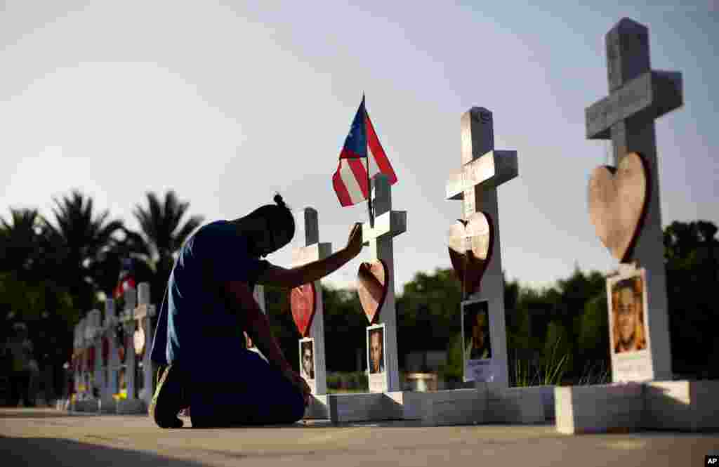 Ernesto Vergne prays at a cross honoring his friend Xavier Emmanuel Serrano Rosado and the other victims at a memorial to those killed in the Pulse nightclub mass shooting, a few blocks from the club in Orlando, Florida.