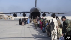 Watu wakipanda katika ndege tayari kuondolewa kutoka Afghanistan katika ndege ya kijeshi ya Jeshi la Anga la Marekani C-17 Globemaster III katika uwanja wa ndege wa Kimataifa wa Hamid Karzai. Agosti. 24, 2021. (Master Sgt. Donald R. Allen/U.S. Air Force via AP).