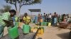 FILE - Displaced people, who fled from attacks of armed militants in town of Roffenaga, carry their jerrycans at the water point near UNHCR camp in Pissila, Burkina Faso, Jan. 24, 2020. 