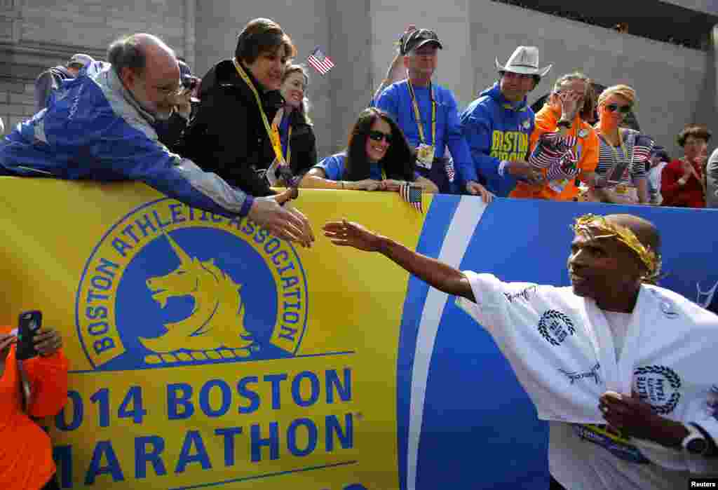 Meb Keflezighi of the U.S. (right) is congratulated after winning the men's division of the 118th running of the Boston Marathon. Keflezighi is the first U.S. male athlete to win the Boston Marathon in three decades, Boston, Mass., April 21, 2014.