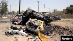 Beberapa kendaraan hancur terlihat di TKP bom bunuh diri di Khalis, sebelah utara Baghdad, Irak Senin (25/7).
