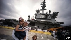 Kru kapal induk Angkatan Laut Amerika bertenaga nuklir USS Ronald Reagan disambut oleh keluarga mereka di Pangkalan Angkatan Laut AS di Yokosuka, utara Tokyo (1/10).