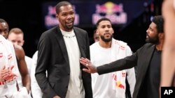 NBA player Kevin Durant who smiles as he stands to greet teammates returning to the bench during a timeout in the second half of an NBA basketball game against the New York Knicks, Dec. 26, 2019.