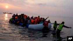 Des bénévoles aident des migrants et refugiés oà débarquer sur l'île de Lesbos, en Grèce, le 20 mars 2016.
