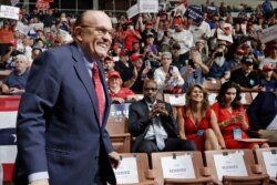 FILE - Former New York City Mayor Rudy Giuliani smiles as he arrives to President Donald Trump's campaign rally in Manchester, N.H.