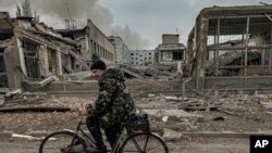 Një burrë kalon me biçikletë përpara zyrës së postës, e cila u shkatërrua nga një sulm ajror rus në qytetin Kurakhove, rajoni Donetsk, Ukrainë, më 7 nëntor 2024.
