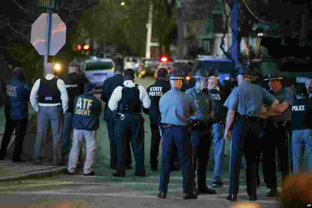 Officers look on as the search for a suspect in the Boston Marathon bombings continues, April 19, 2013, in Watertown.