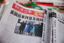 FILE - A copy of the Global Times newspaper featuring an image of U.S. President Joe Biden and Vice President Kamala Harris on its front page is seen at a newsstand in Beijing, China, Jan. 21, 2021.