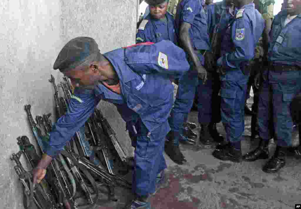 A Congo government policeman hands in his weapon to M23 rebels during an M23 rally in Goma, DRC, November 21, 2012.