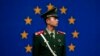 FILE - A Chinese policeman stands in front of the European Union flag outside the office of the European Union delegation to China in Beijing, Oct. 28, 2011. The chamber said the EU is unlikely to lift trade barriers this year because of fears Chinese exports are causing job losses.