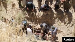 Para penduduk desa mengumpulkan jenazah penduduk sipil yang dibunuh oleh kaum pemberontak di desa Mirza Olang, di provinsi Sar-e Pul, Afghanistan, 15 Agustus 2017. (Foto:dok)