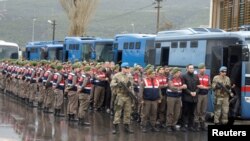 FILE - Turkish soldiers accused of attempting to assassinate President Tayyip Erdogan on the night of the failed July 15 coup, are escorted to court in Mugla, Turkey, March 8, 2017. On Thursday more arrest warrants were issued for Turkish soldiers.