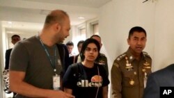 Kepala Polisi Imigrasi Mayjen Surachate Hakparn (kanan), berjalan dengan Rahaf Mohammed Alqunun sebelum meninggalkan Bandara Suvarnabhumi, Bangkok, Thailand, 7 Januari 2019. (Foto: Polisi Imigrasi via AP) 