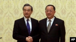Menteri Luar Negeri Korea Utara Ri Yong Ho (kanan) berpose dengan Menlu China Wang Yi di Balai Pertemuan Mansudae di Pyongyang, Korea Utara, Rabu, 2 Mei 2018. (Foto AP / Jong Chul Jin)