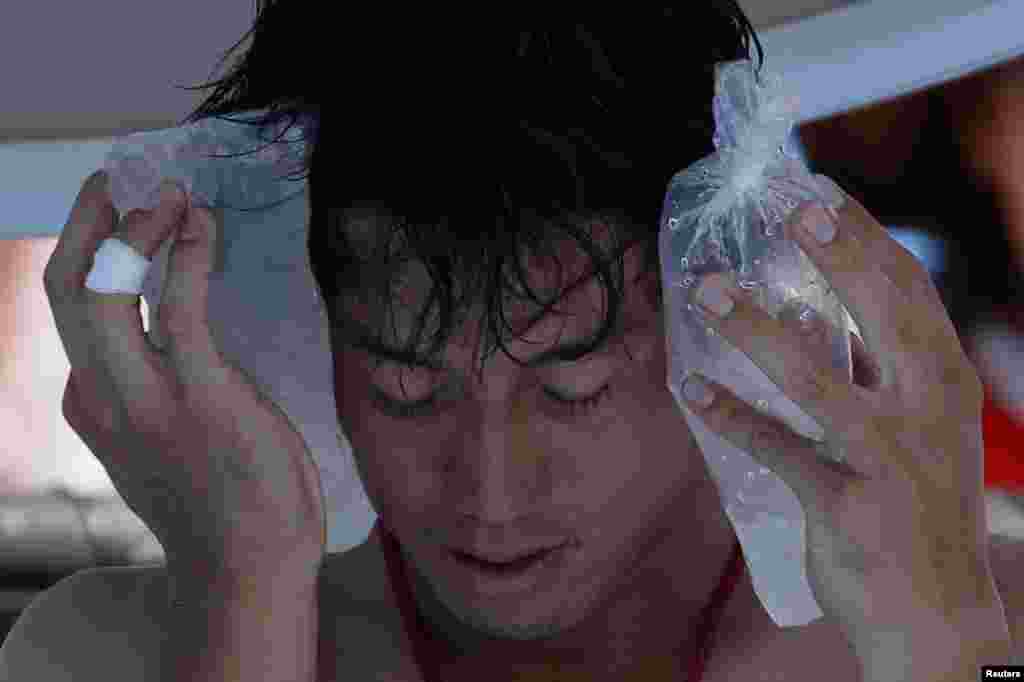 Kei Nishikori of Japan holds an ice pack to his face during a men's singles match against Dusan Lajovic of Serbia at the Australian Open 2014 tennis tournament in Melbourne. Organizers have been slammed for forcing players to play in searing temperatures.