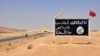 FILE - An Islamic State group poster is seen in the Syrian town of al-Sukhnah, Aug. 13, 2017.
