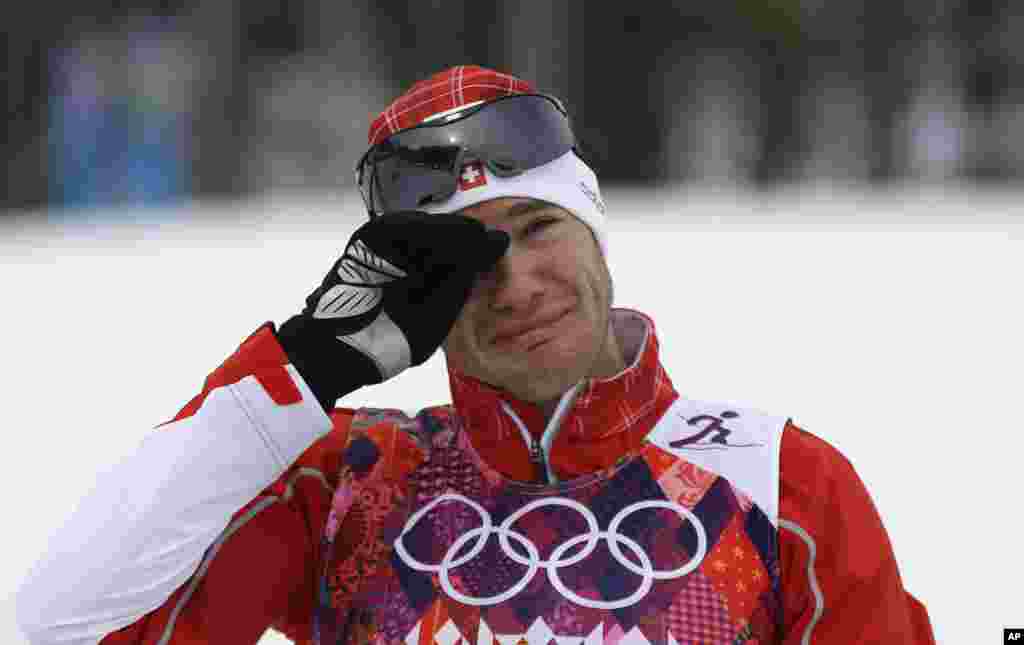 Switzerland's Dario Cologna cries on the podium after winning the gold medal in the men's cross-country 30k skiathlon, Krasnaya Polyana, Russia, Feb. 9, 2014.