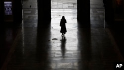 Un passager quitte la gare centrale de Milan, en Italie, le lundi 9 mars 2020. (AP Photo/Antonio Calanni)