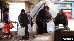 People queue as they fill containers with water in the government controlled al-Rabwah area, a suburb of Damascus, Jan. 10, 2017. 