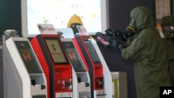 Petugas berseragam dari tim 'hazmat' atau bahan berbahaya memindai mesin-mesin di bandar udara internasional Kuala Lumpur (26/2). (AP/Daniel Chan)