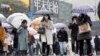 Warga berjalan di penyeberangan Shibuya saat hujan salju turun pada Kamis, 6 Januari 2022, di Tokyo, Jepang. (Foto: AP)