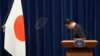 Perdana Menteri Jepang Fumio Kishida membungkuk di depan bendera negara sebelum melaksanakan konferensi pers di kediamannya pada 14 Oktober 2021. Kishida mengatakan rencana pembuangan limbah air pembangkit nuklir di Fukushima harus segera dilakukan. (Foto: AP/Eugene Hoshiko)