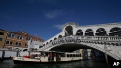 Para pemrotes memasang spanduk bertuliskan "#Venexodus" di jembatan Rialto, Venesia, Italia, 12 November 2016 (AP Photo/Luca Bruno).