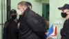 Syarhei Tsikhanouski, a video blogger and the husband of Belarus' opposition leader Sviatlana Tsikhanouskaya, is escorted before a court hearing in Gomel (Homel), Dec.14, 2021. (Sergei Kholodilin/BelTA/Handout)