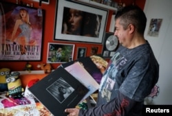 Roberto Santos menunjukkan hadiah-hadiah eksklusif dari ikon pop AS, berpose di "kuil Taylor Swift" sambil menunjukkan beberapa album di rumahnya di Madrid, Spanyol.