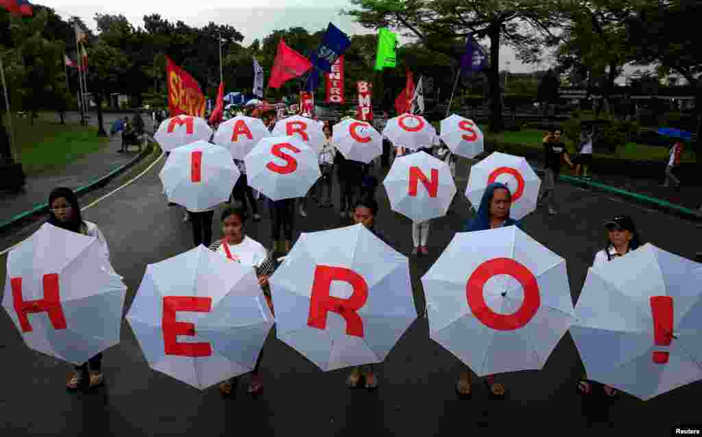 Protesters display umbrellas spelling out "Marcos is no Hero" as they join hundreds of protesters denouncing the planned burial of late dictator Ferdinand Marcos at the Libingan ng mga Bayani (Heroe's Cemetery) during a protest at a park in metro Manila, Philippines.