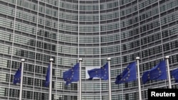 FILE - European Union flags are seen outside the European Commission headquarters in Brussels.