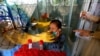 FILE - A girl reacts while having a nasal swab sample taken by a health worker at a COVID-19 testing facility in a hospital in Karachi, Pakistan, March 18, 2021. 
