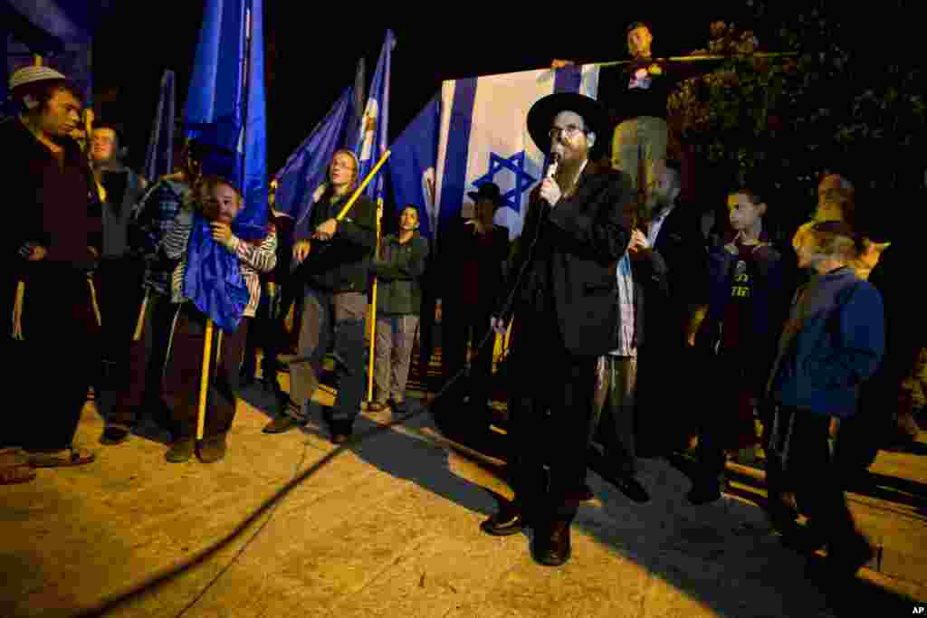 Right wing Israelis protest at the scene where Yehuda Glick, a rabbi and activist, who has pushed for greater Jewish access to Al Aqsa Mosque compound, survived an assassination attempt last week, in Jerusalem, Nov. 6, 2014.