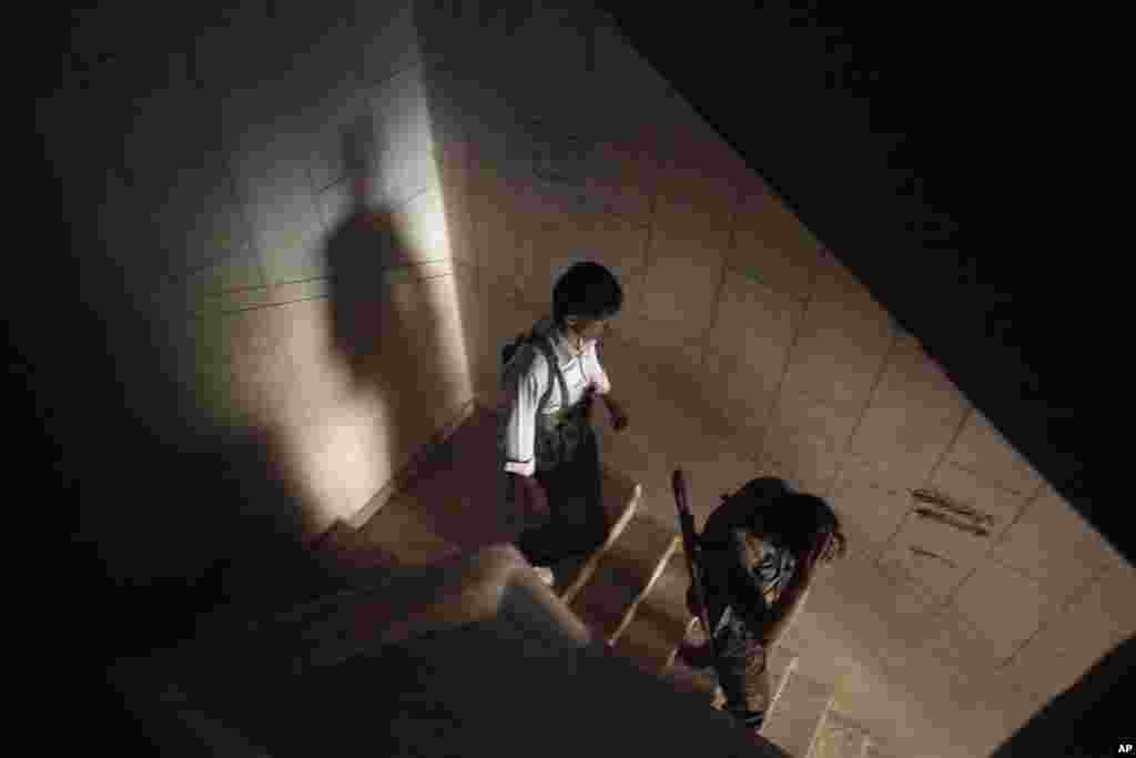 Free Syrian Army fighters walk down stairs in a damaged building in Aleppo, Syria, September 26, 2012.