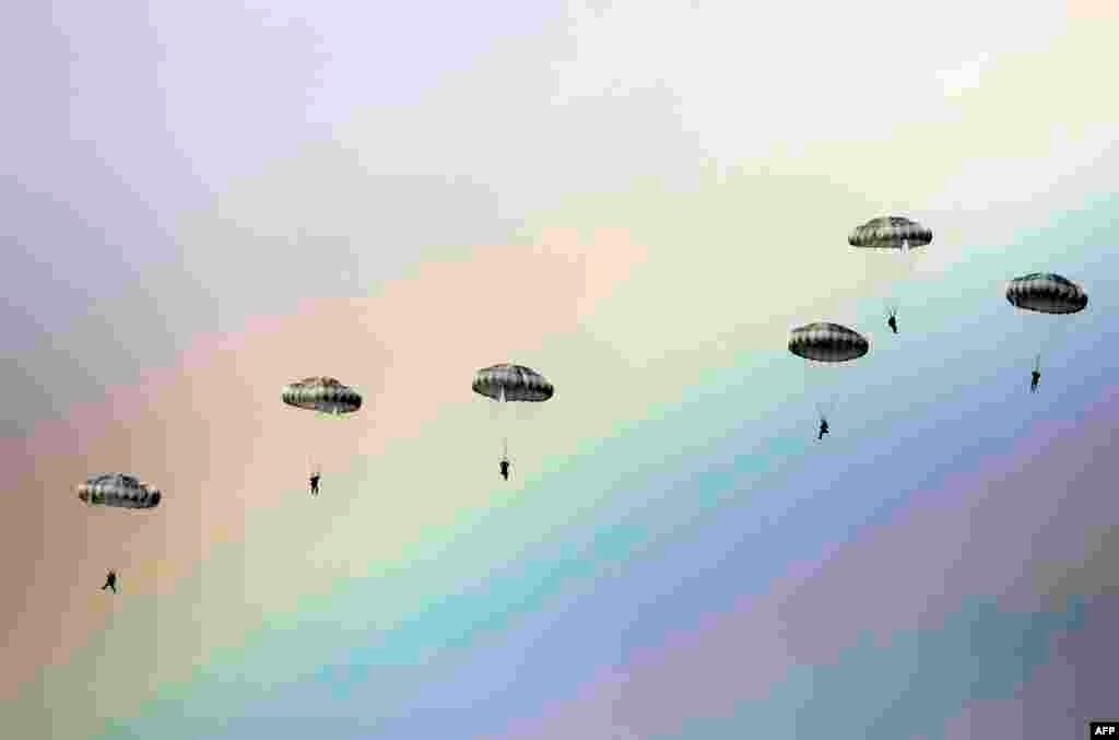 Russian paratroopers jump as a rainbow appears in the sky during the joint Russian, Belarusian and Serbian military exercise "The Slavic Brotherhood" at the military ground Kovin, near Belgrade.