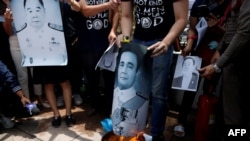 Mahasiswa pro-demokrasi membakar potret Perdana Menteri Thailand Prayuth Chan-o-cha di depan Gedung Pemerintah di Bangkok, Thailand, 24 Juli 2020. (Foto: REUTERS/Jorge Silva)
