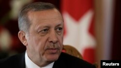 FILE - Turkish President Recep Tayyip Erdogan listens during a news conference in Riga.