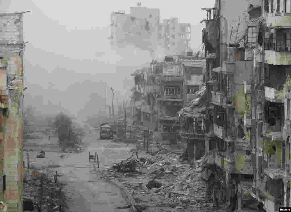 Asap mengepul dari bangunan setelah apa yang disebut para aktivis sebagai pemboman yang dilakukan oleh pasukan setia Presiden Suriah Bashar al-Assad di daerah yang terkepung, Homs, 15 Januari 2014.