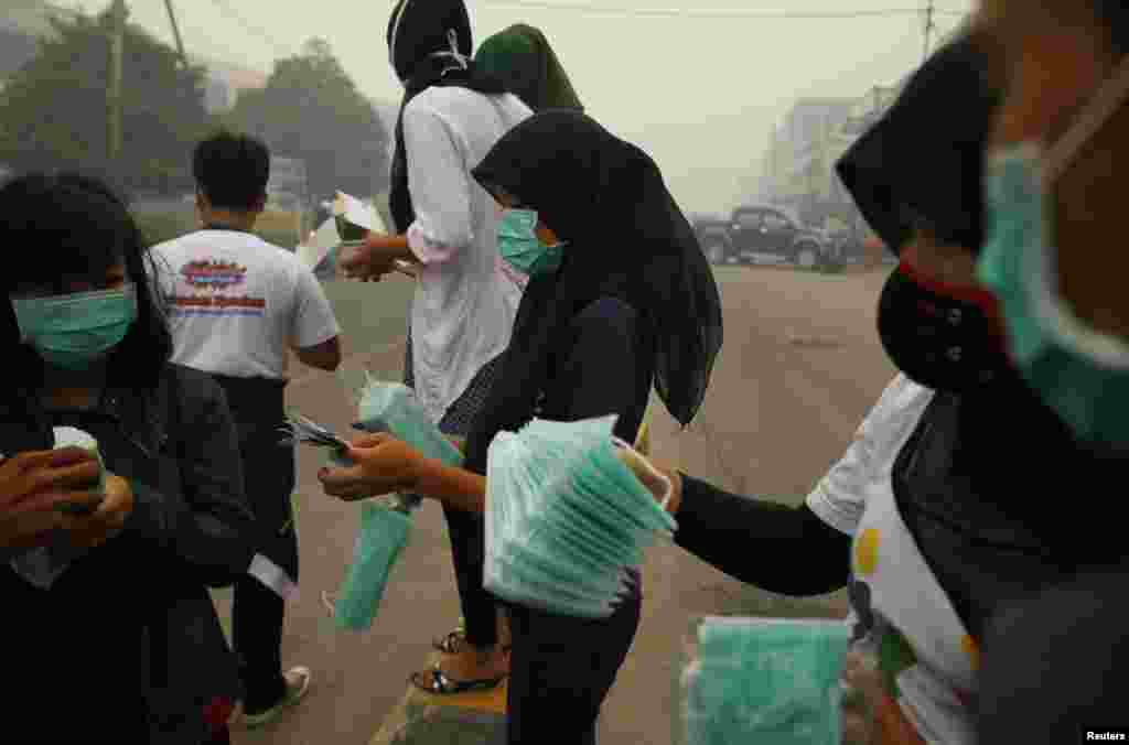 Volunteers prepare new face masks to give to residents in Dumai, Indonesia, June 21, 2013. 
