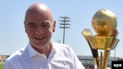 Le président de la FIFA, Gianni Infantino, tient un trophée dedié aux "travailleurs de la Coupe du au Qatar 2016" à Doha, Qatar, 22 avril 2016. epa/ STRINGER