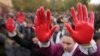 Protesters shout slogans with red paint on thire hands symbolizing blood, demanding arrests, two days after a concrete canopy collapsed at a railway station in Novi Sad, killing 14 people and injuring three, during a protest in Belgrade, Nov. 3, 2024. 