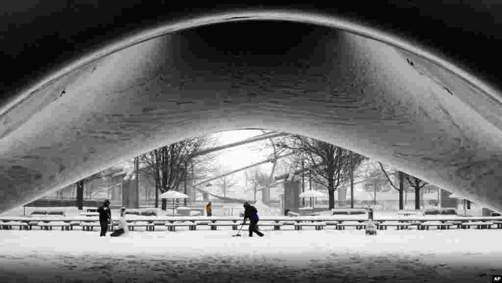 A park crew clears the snow around Annish Kapoor&#39;s stainless steel Cloud Gate sculpture at Millennium Park as snow continues to accumulate in downtown Chicago, Illinois, USA.