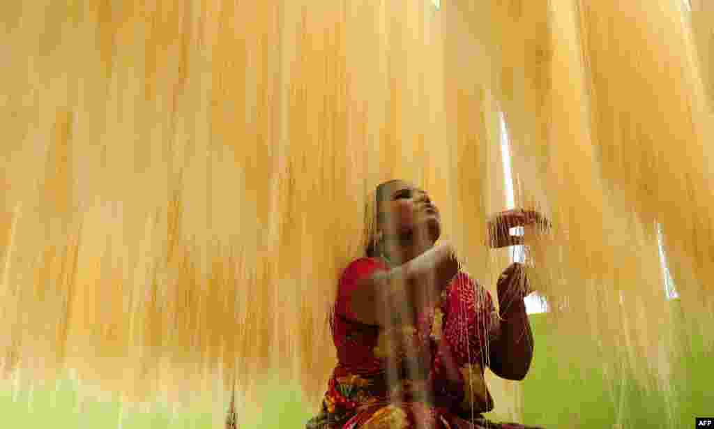 An Indian woman sorts strands of drying seviiyan - thin vermicelli - which is used for the preparation of 'sheerkhorma', a traditional sweet dish prepared by muslims during the holy month of Ramadan, at a food factory in Chennai.