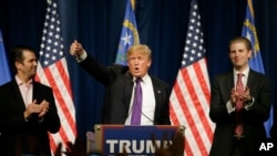 Kandidat capres AS dari partai Republik, Donald Trump, didampingi dua puteranya Donald Trump Jr., (kiri) dan Eric, saat berpidato pada malam kaukus di Las Vegas (23/2).