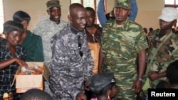 General Sultani Makenga, military leader of the M23 rebels, distributes snacks to children during celebrations to mark the Day of the African Child, at the Catholic church in the town of Rutshuru, eastern Democratic Republic of Congo, June 16, 2013.